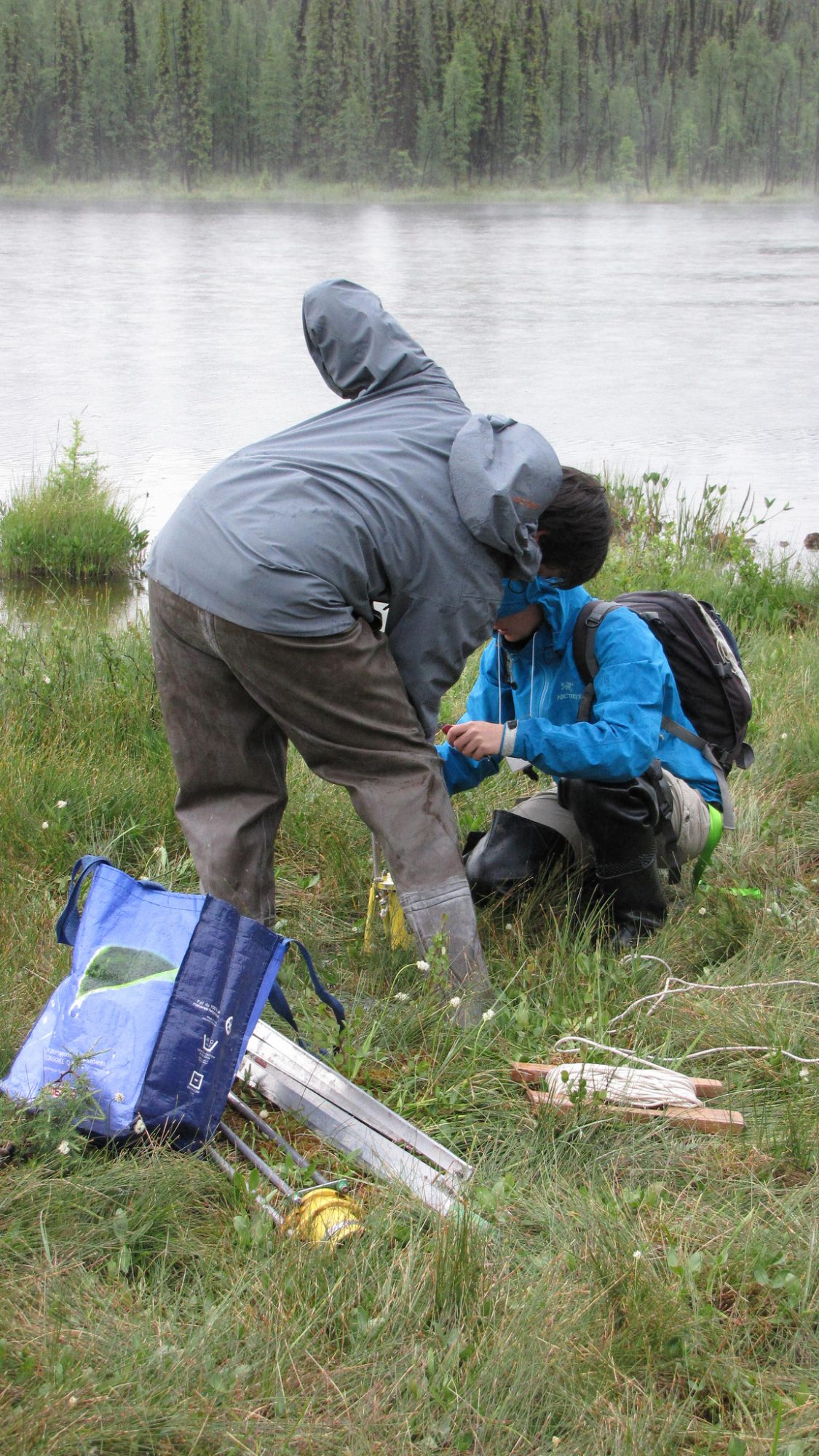 people setting up a water measuring device